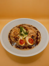 A bowl of Creamy Chicken & Mushroom Ramen on a warm orange background