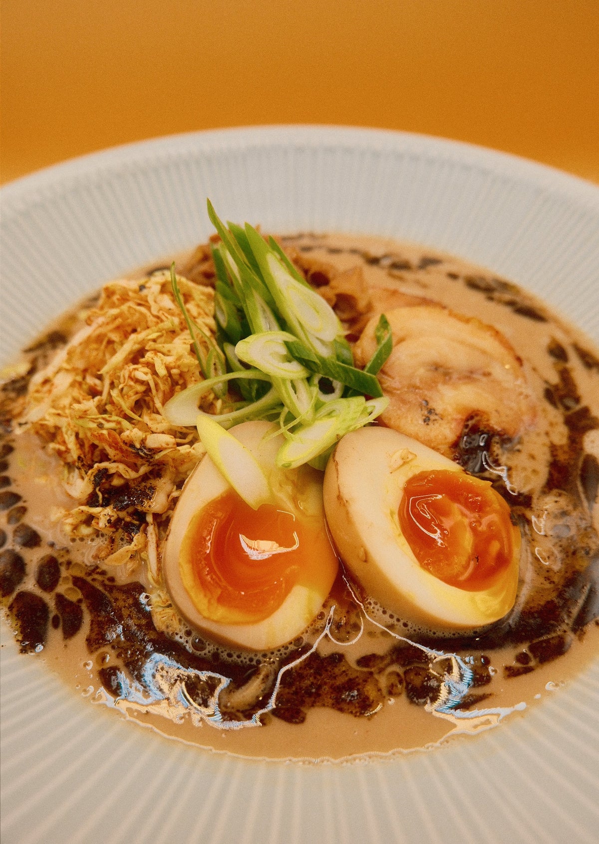 Close-up of Creamy Chicken & Mushroom Ramen with chicken chashu, mushroom ragu and a halved egg