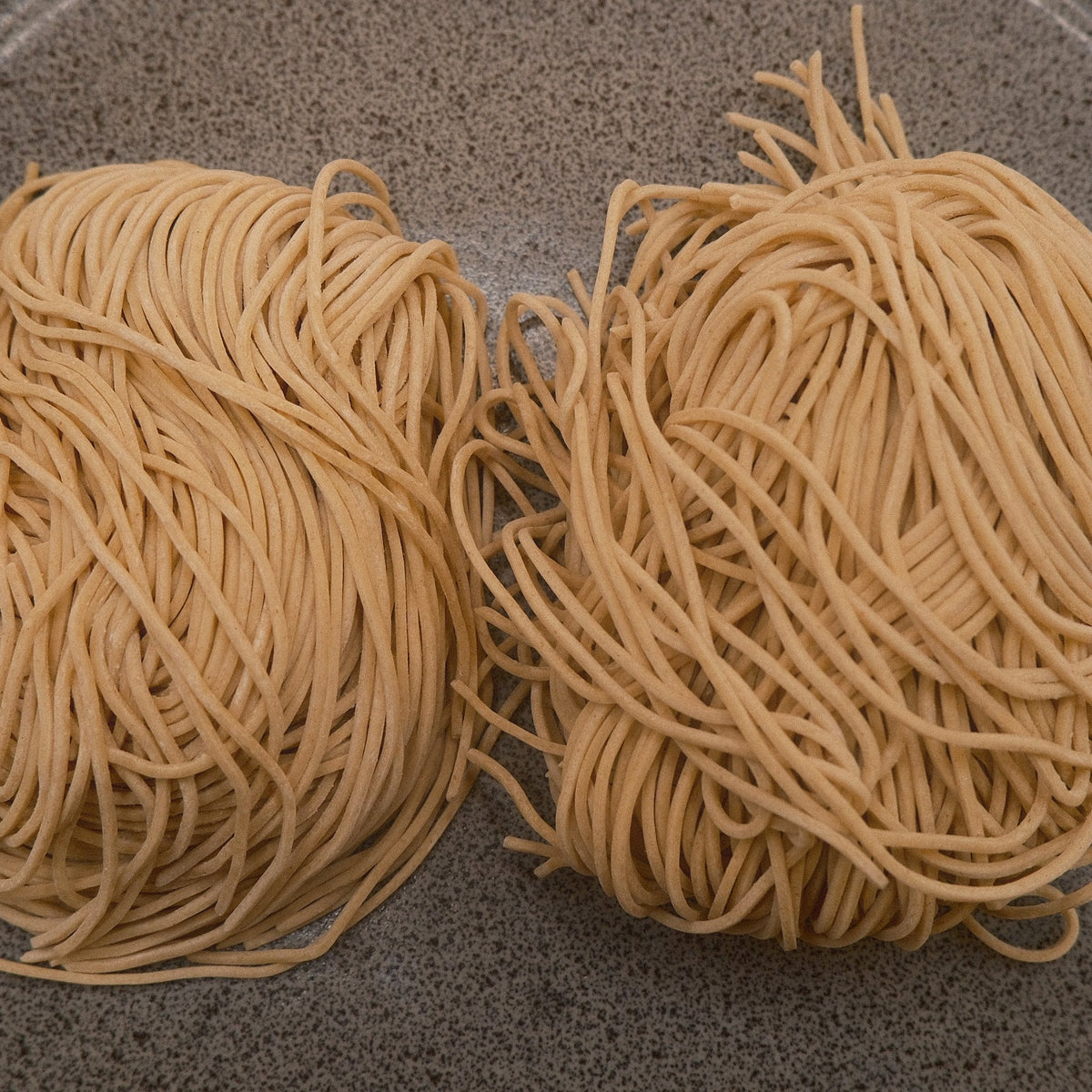 Two nests of thin Hakata style noodles, one portion each