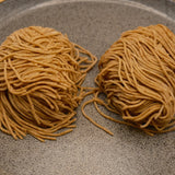 Two nests of rye Tokyo style noodles on a stone plate, one portion each