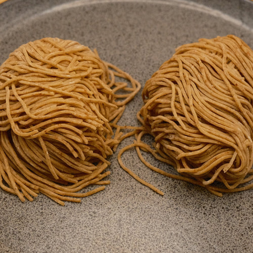 Two nests of rye Tokyo style noodles on a stone plate, one portion each